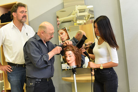 Drei Personen an einem Model