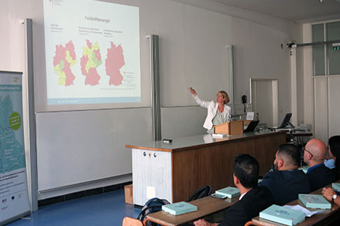 Eine Frau zeigt auf eine Leinwand