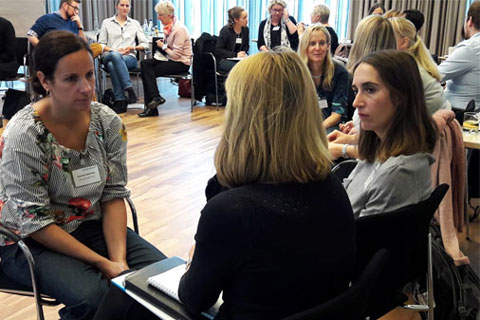 Mehrere Personen sitzen im Stuhkreis