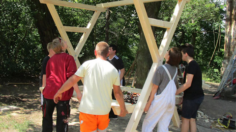 Mehrere Personen tragen ein Holzgestell