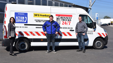 Drei Personen stehen vor einem Lieferwagen
