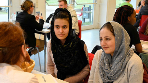 Drei Personen sitzen an einem Tisch