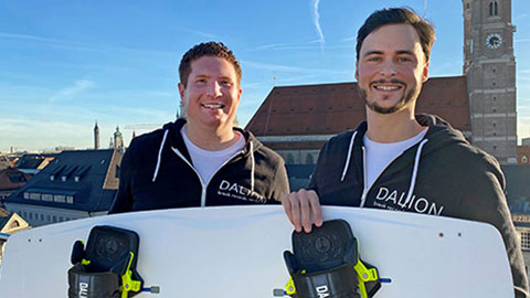 Zwei Männer halten ein Kiteboard