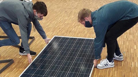 Zwei Männer mit einer Solarzelle