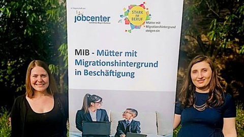 Zwei Frauen neben einer Leinwand