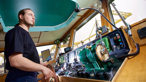 Ein Mann steuert ein Boot