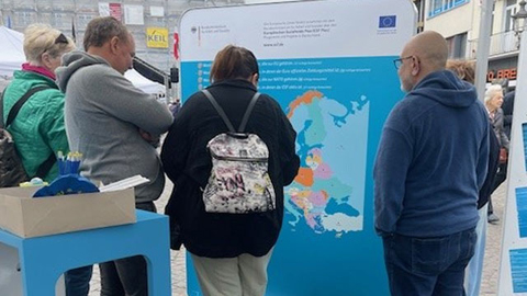 Mehrere Personen stehen an der EU-Wand