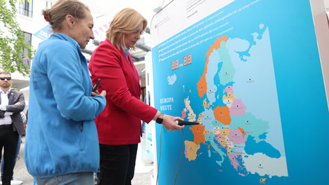 Bundesarbeitsministerin Bärbel Bas und Barbara Braun aus dem Bundesarbeitsministerium stehen zusammen vor einer Europakarte.